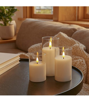 Drei LED Echtwachs Kerzen in Gläsern stimmungsvoll auf einem Tisch arrangiert.
